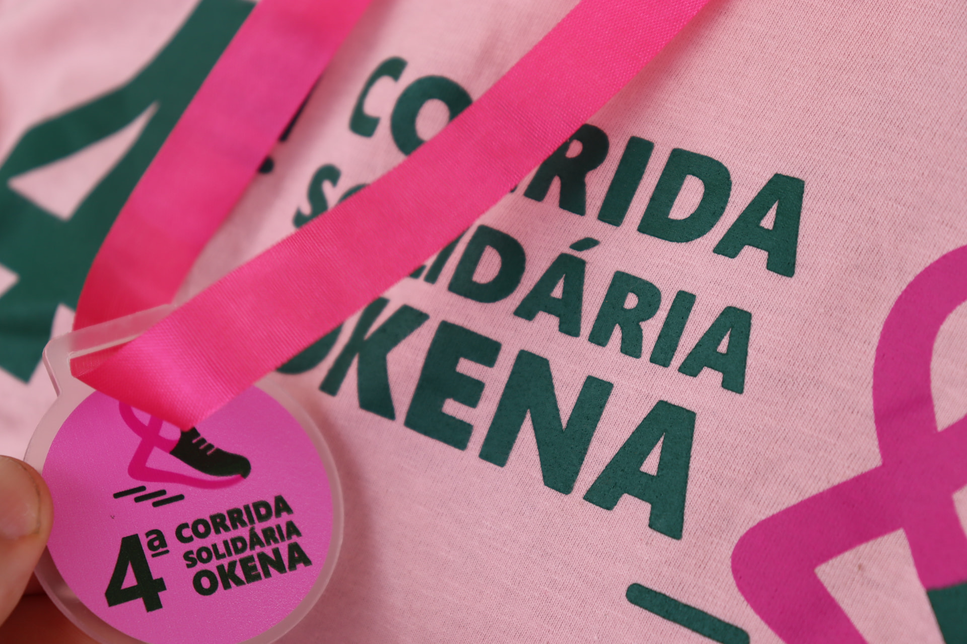 Detalhe da medalha e da camiseta da 4ª Corrida Solidária Okena